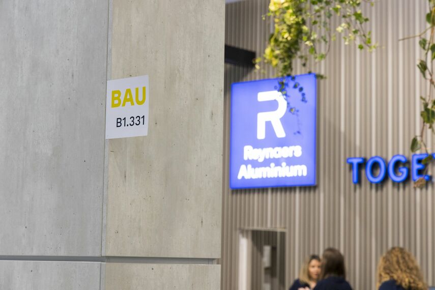 Logo Reynaers Aluminium na stěně stánku BAU 2023.