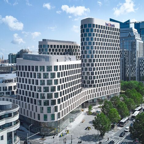 Futuristická bílá kancelářská budova s křivkami v Bruselu.