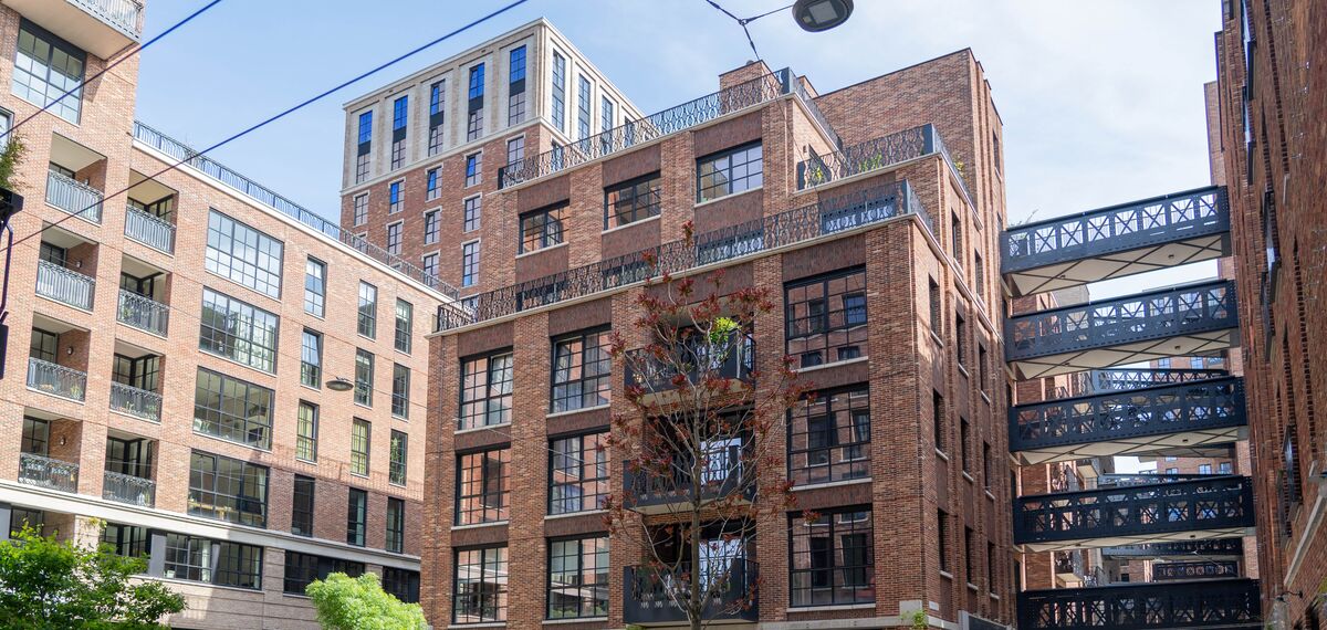 Cihlová a ocelová budova v moderní městské čtvrti.