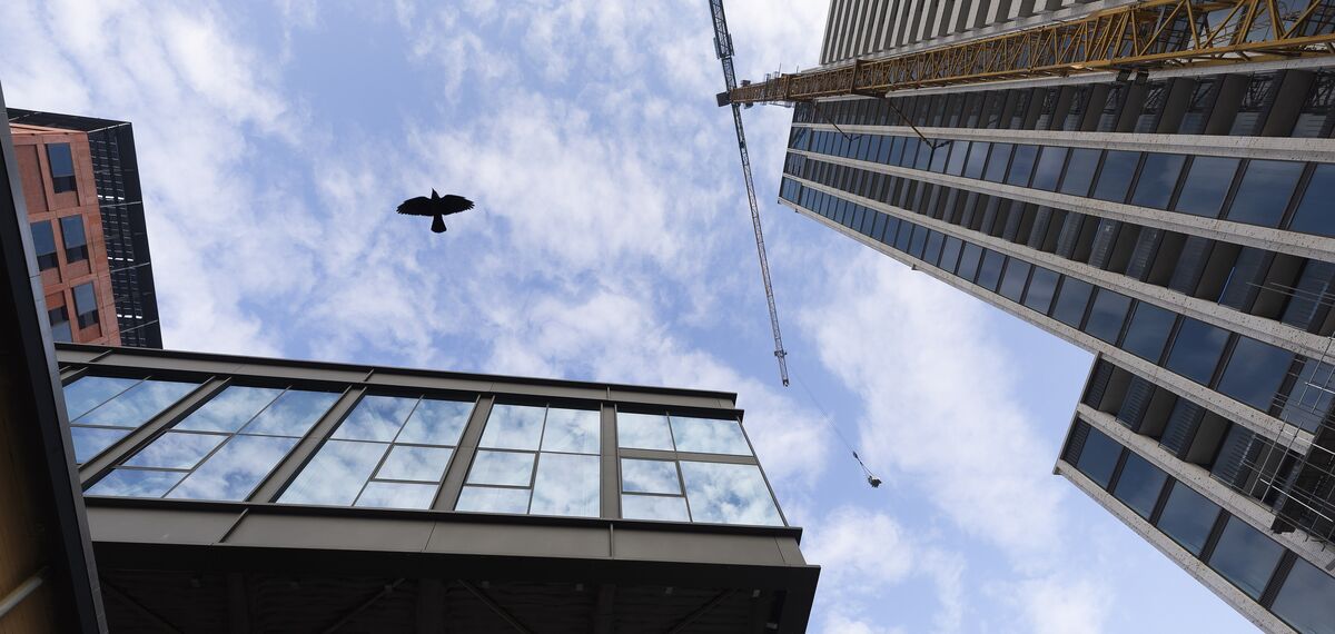 Upward view of building and construction site with blue sky.