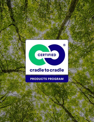 Logo Cradle to Cradle před zelenými korunami stromů.